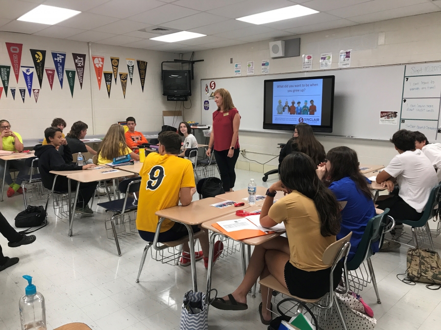 guest speaker in a room with students and pennants on the wall